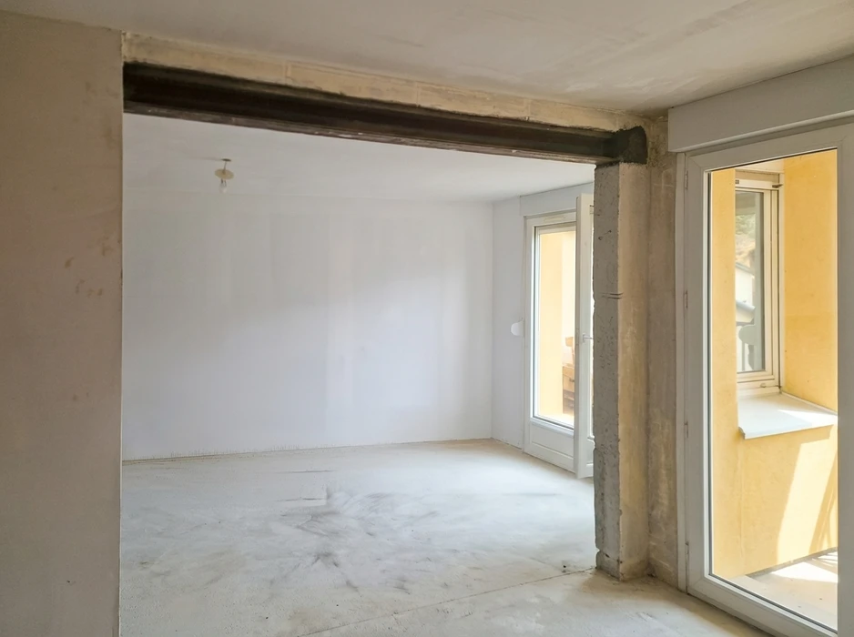 Pièce vide en cours de rénovation, vue depuis une ouverture murale