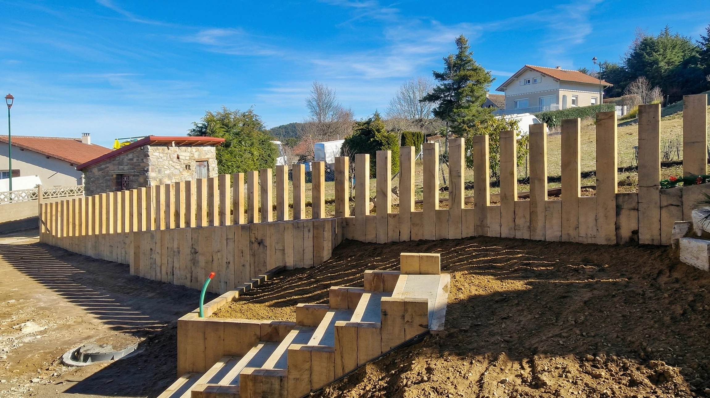 Maison moderne à deux niveaux avec bardage bois vertical, située dans un quartier résidentiel